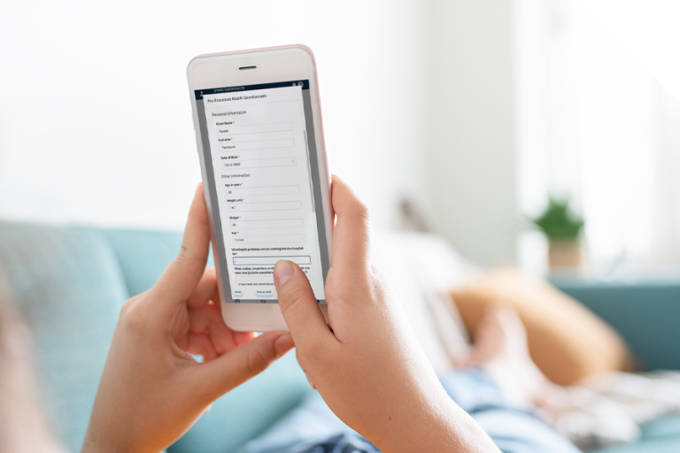 Patient completing digital from on mobile while lying on coach