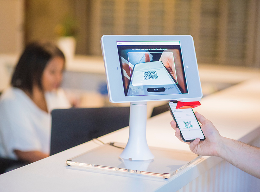 Person scanning QR code through check-in kiosk scanner