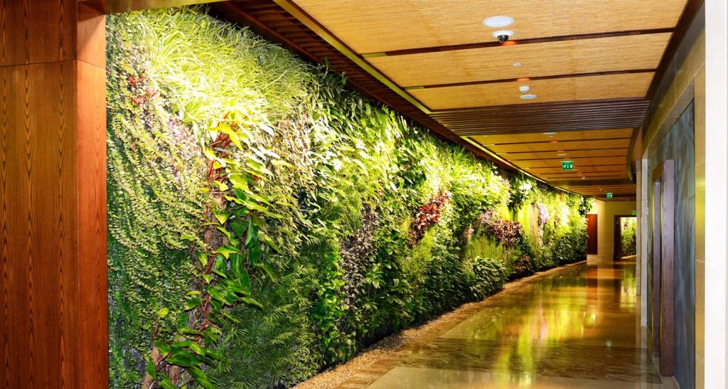 Interior of hallway in night illumination with green plants across wall