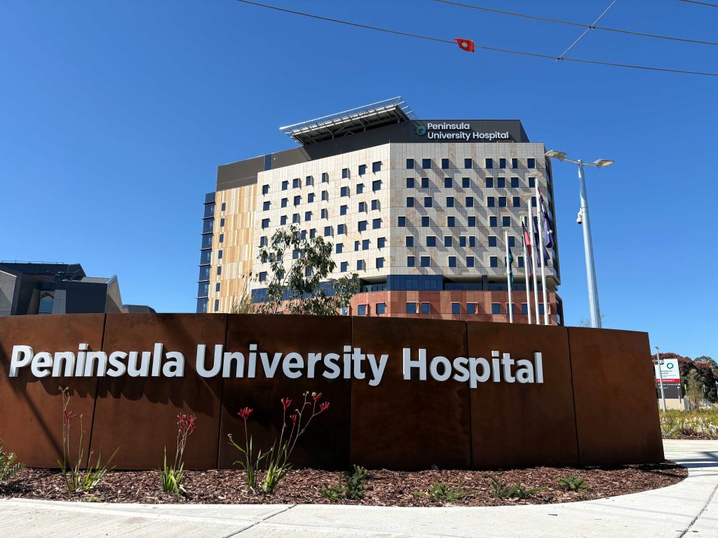 Peninsular University Hospital sign with hospital in the background